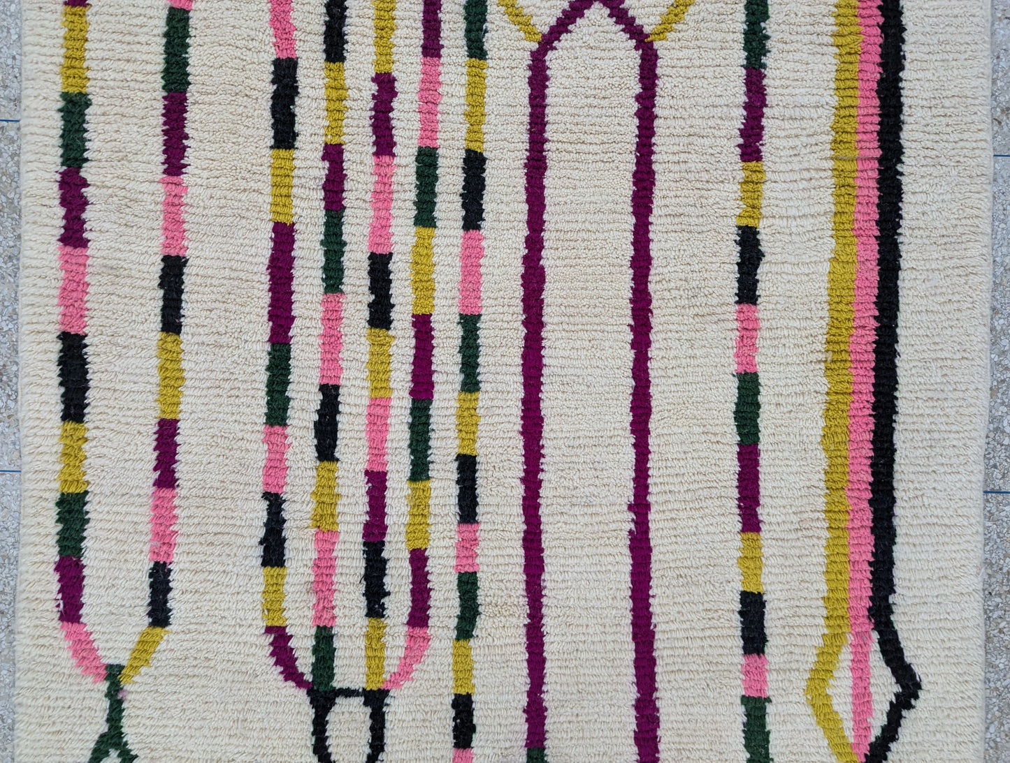 Détail central du tapis Beni Ouarain – motifs noirs dessinés à la main sur laine écrue