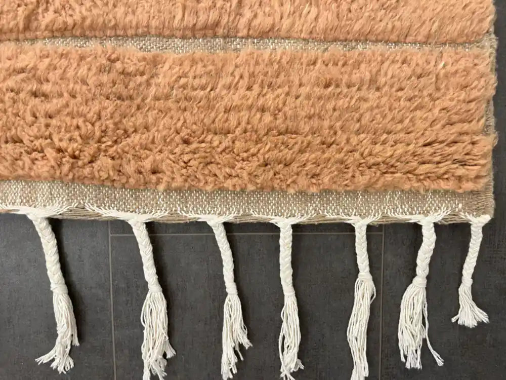 Bordure frangée blanche d’un tapis berbère marron Beni Ouarain, fait main au Maroc