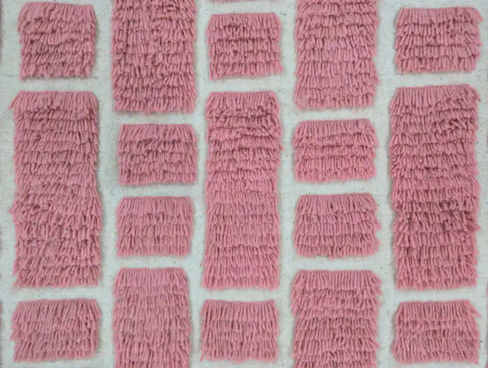 Motifs roses géométriques sur un tapis berbère en laine tissé main