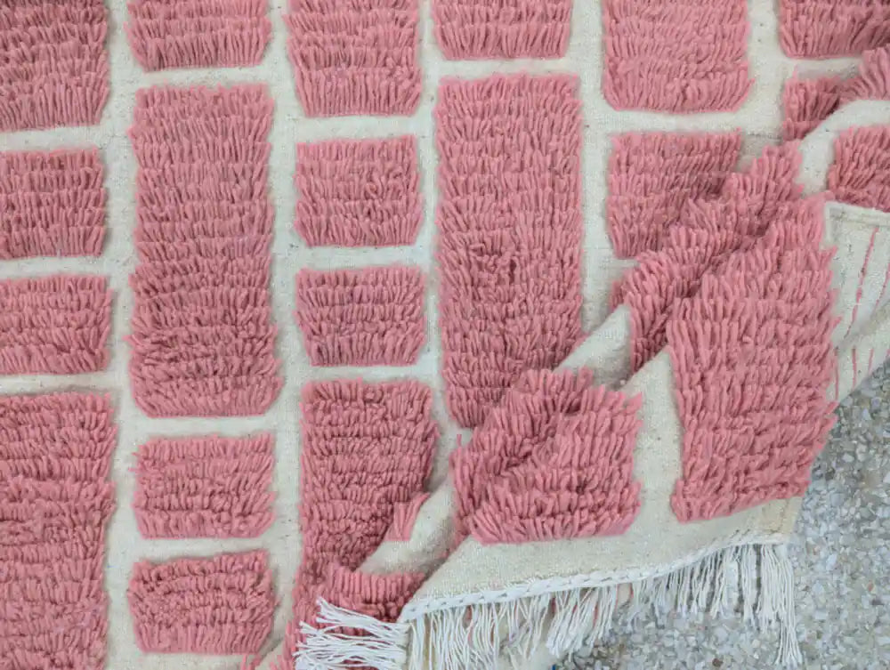 Revers visible d’un tapis berbère en laine rose traditionnel fait main