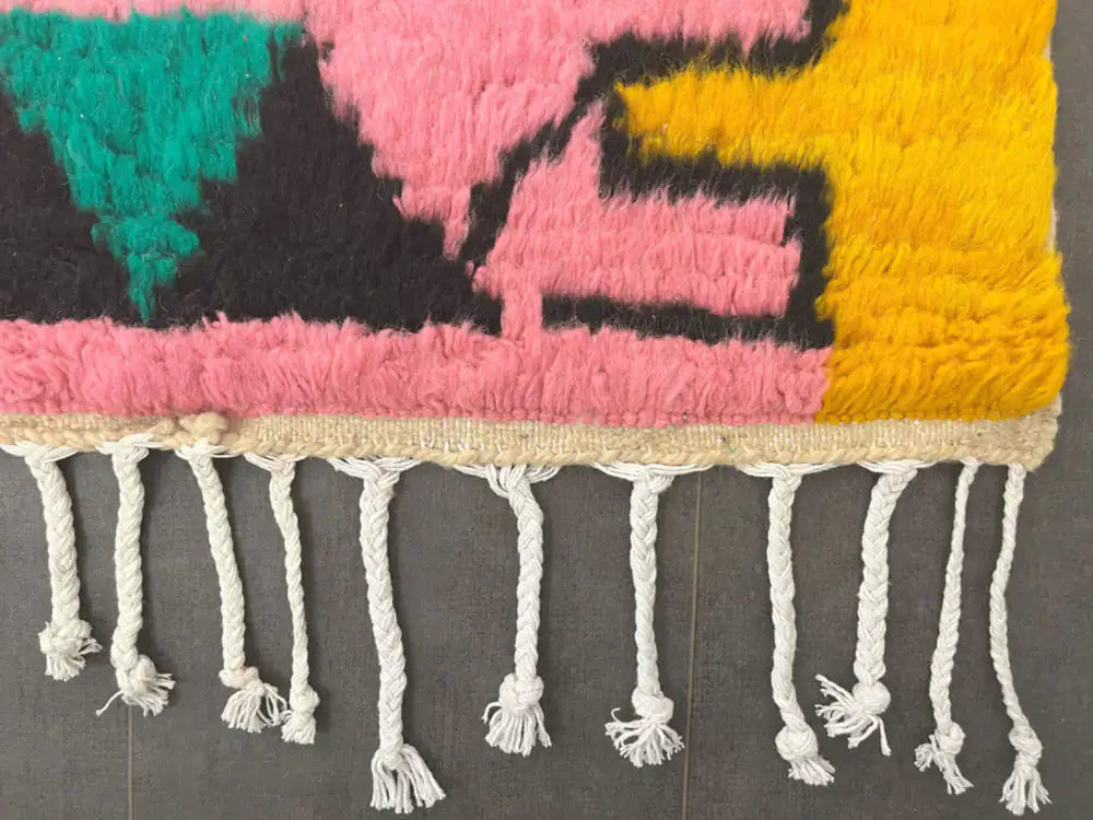 Bordure du tapis azilal coloré avec franges blanches nouées à la main, finitions artisanales berbères