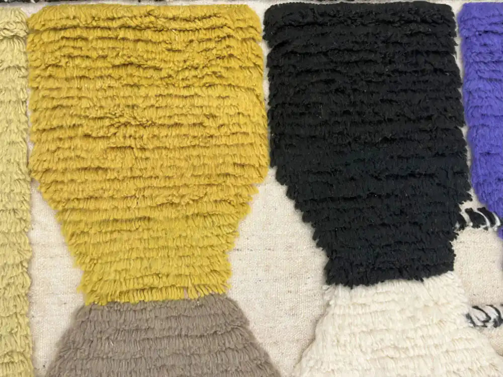 Gros plan sur les motifs géométriques du tapis azilal multicolore avec jaune et noir