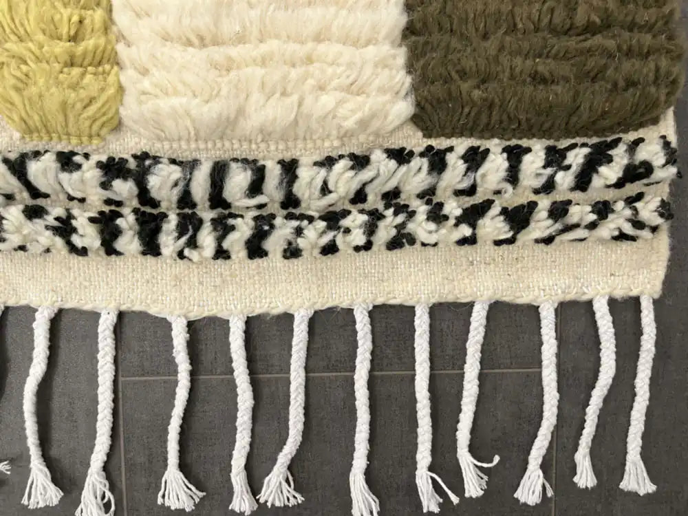 Détail des franges et des bordures noires et blanches du tapis azilal multicolore