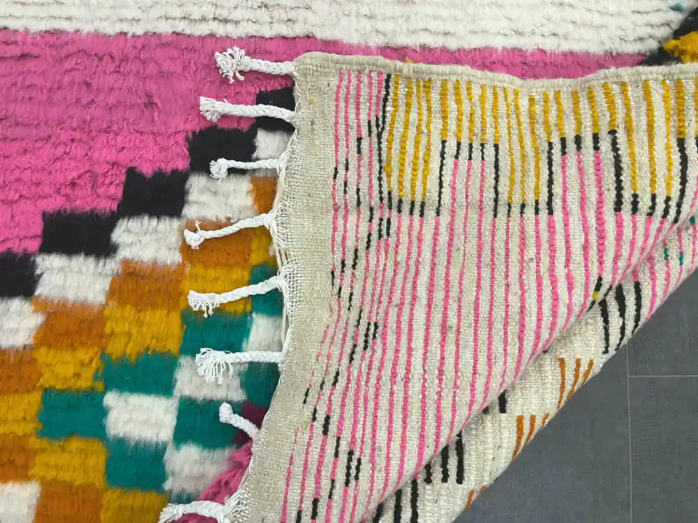 Revers tissé du tapis azilal coloré révélant les lignes fines et la structure du tissage marocain