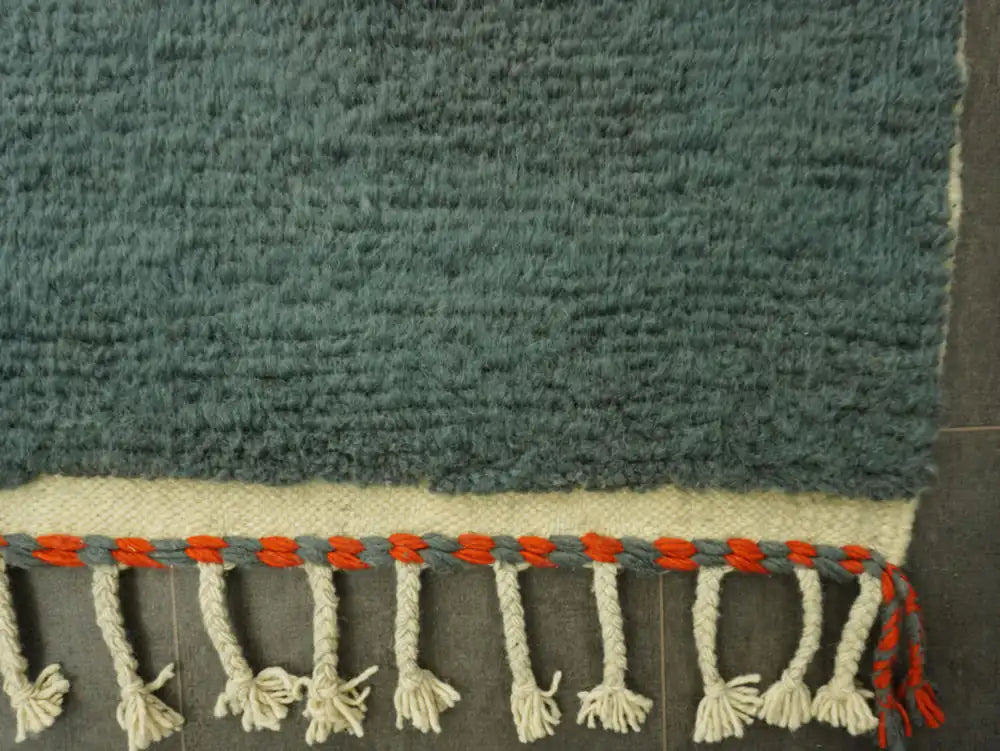 Franges tressées du tapis Beni Ouarain, finitions artisanales marocaines avec touches rouges et grises