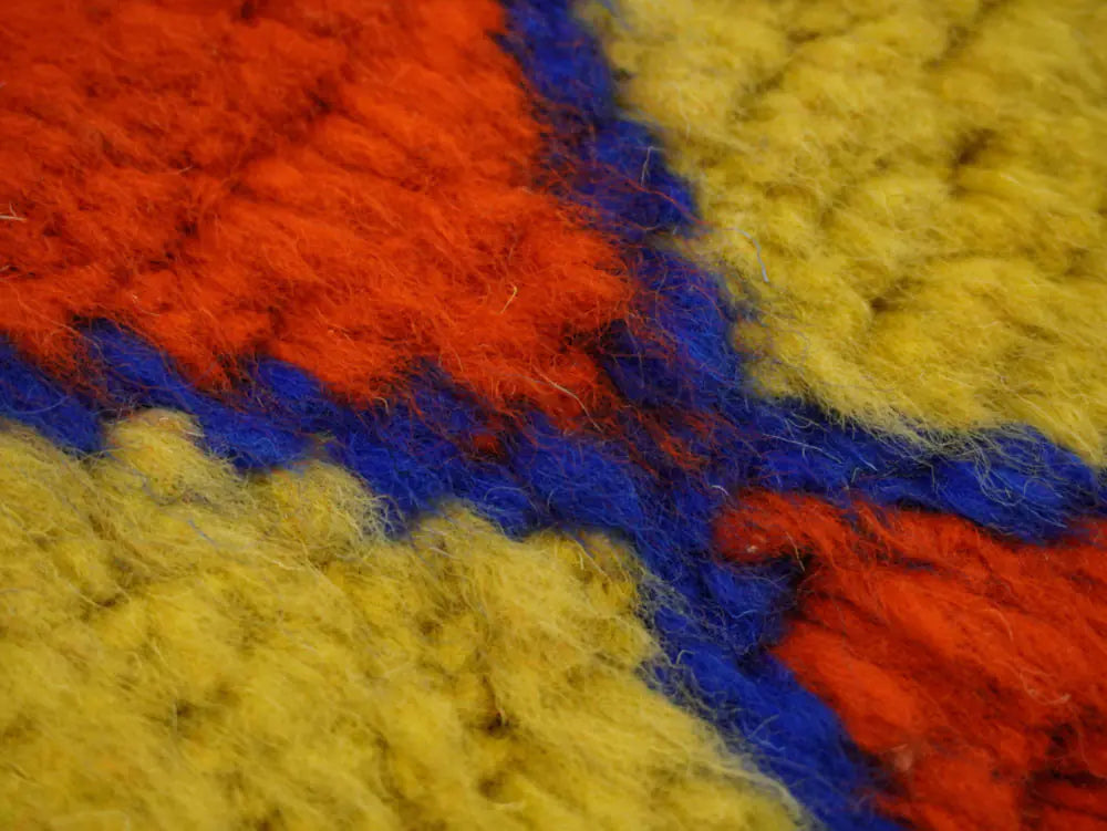 Gros plan sur la laine naturelle du tapis Beni Ouarain, texture douce et artisanale, motif berbère coloré