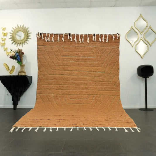 Grand tapis Beni Ouarain marron posé dans un salon moderne au style marocain épuré