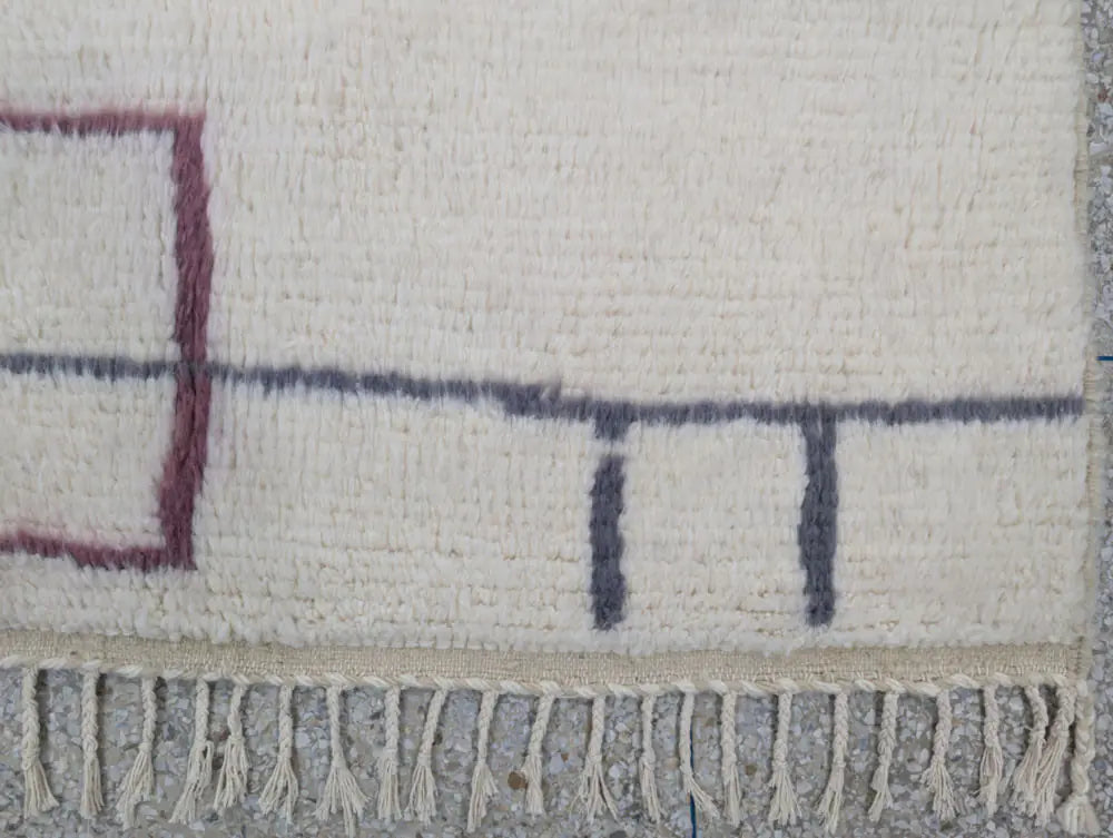 Franges nouées à la main d’un tapis berbère moderne, finition soignée et authentique