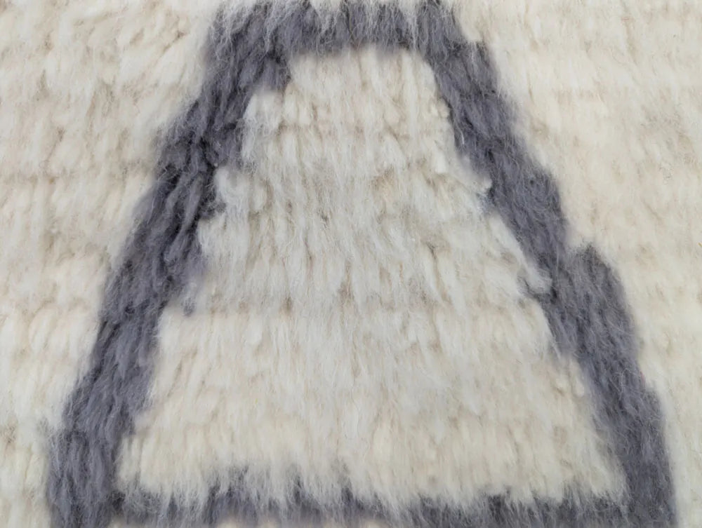 Zoom sur la texture épaisse d’un tapis en laine tissé à la main, design graphique marocain