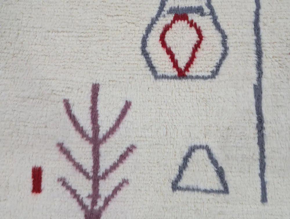 Détail des dessins géométriques sur un tapis marocain artisanal en laine écrue, style moderne