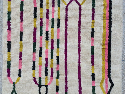 Détail central du tapis Beni Ouarain – motifs noirs dessinés à la main sur laine écrue