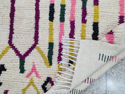 Tapis Beni Ouarain plié pour montrer la souplesse de la laine et l’envers du tissage