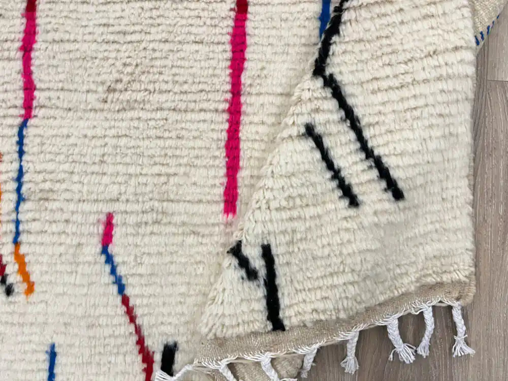 Tapis Azilal plié montrant la frange et la texture de la laine naturelle, reflet du travail artisanal.