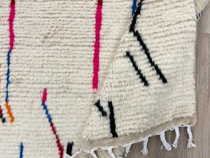 Tapis Azilal plié montrant la frange et la texture de la laine naturelle, reflet du travail artisanal.