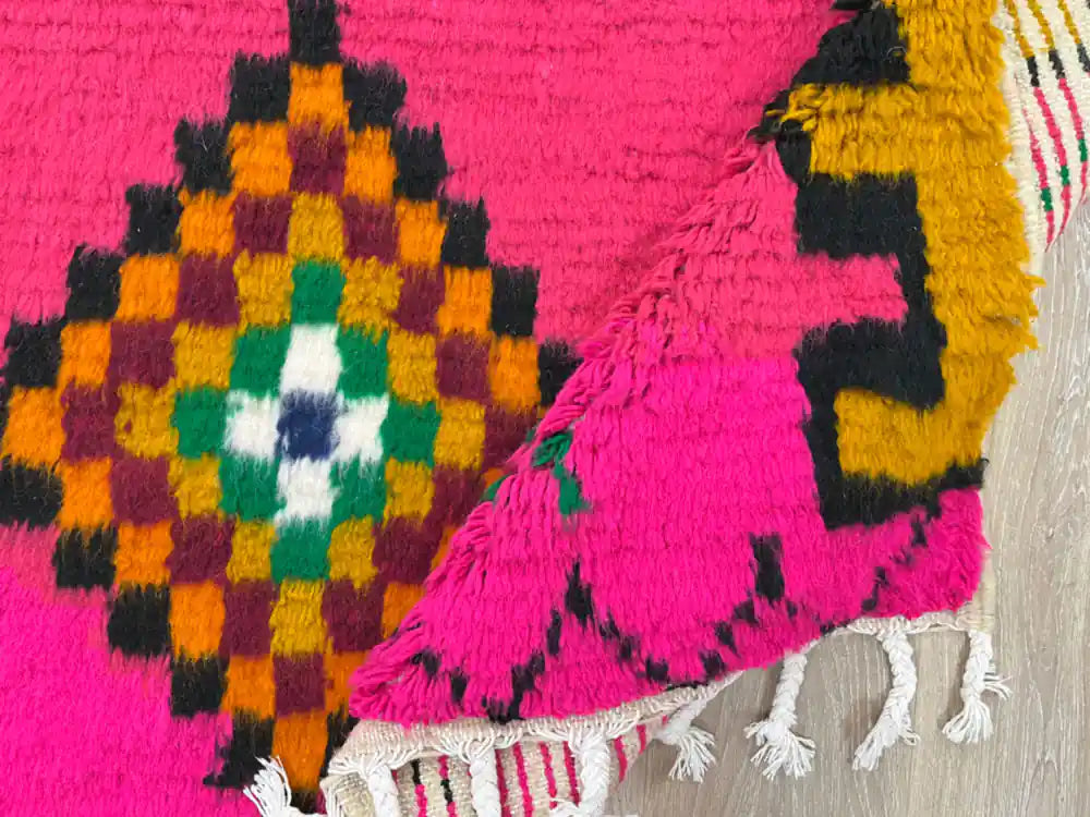 Tapis Azilal plié montrant la laine naturelle et les franges artisanales