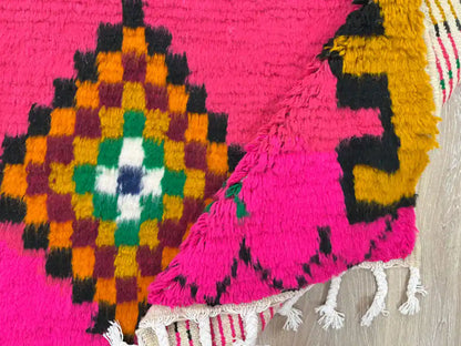 Tapis Azilal plié montrant la laine naturelle et les franges artisanales