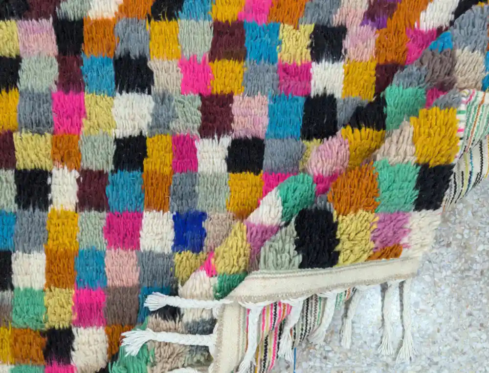 Tapis Azilal plié mettant en évidence la frange et la qualité de la laine naturelle épaisse.