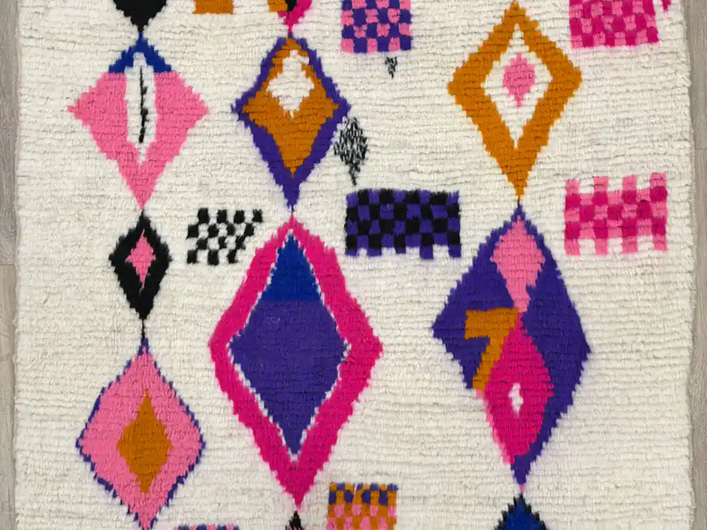 Détail central du tapis berbère Azilal montrant les losanges et symboles colorés tissés à la main.