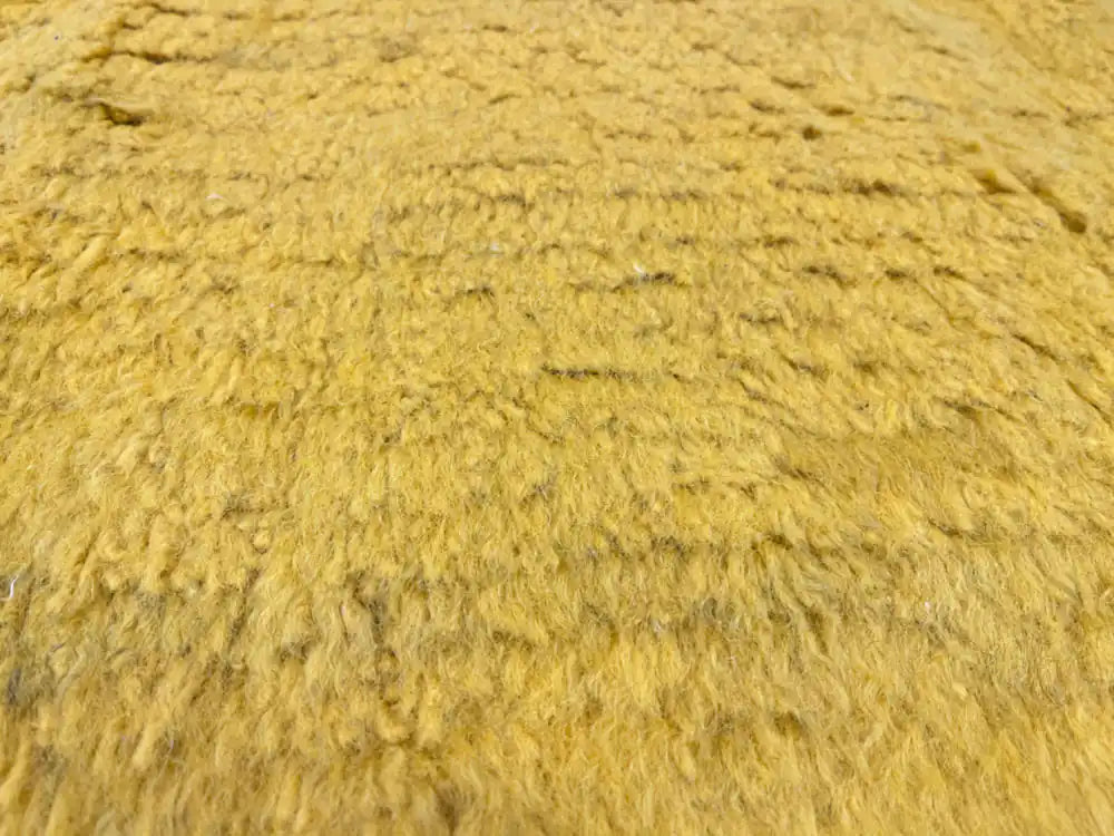 Gros plan sur la laine naturelle du tapis Beni Ouarain, texture dense et douce, fabrication artisanale.