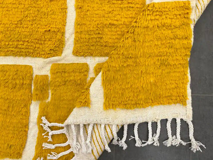 Tapis Beni Ouarain plié montrant la frange et la texture de la laine naturelle, authenticité artisanale.