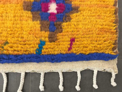 Franges et bordure jaune à motifs géométriques d’un tapis Azilal traditionnel