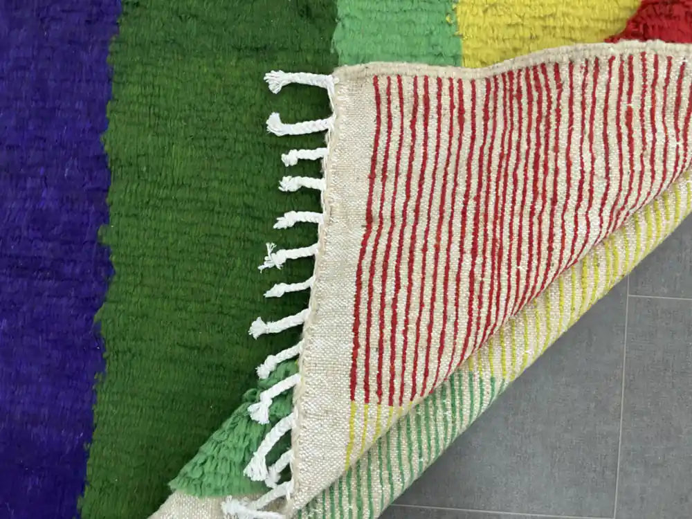 Dos d’un tapis Azilal multicolore authentique avec lignes colorées et nouage fait main