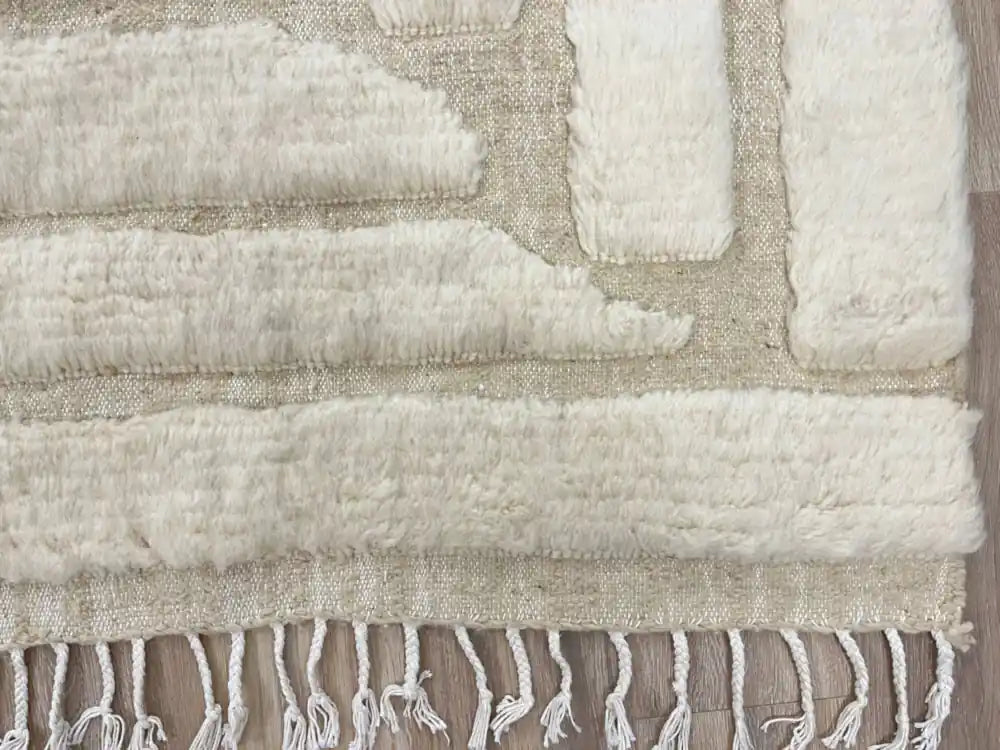 Finition à la main des franges d’un tapis en laine, confort visuel et artisanat authentique