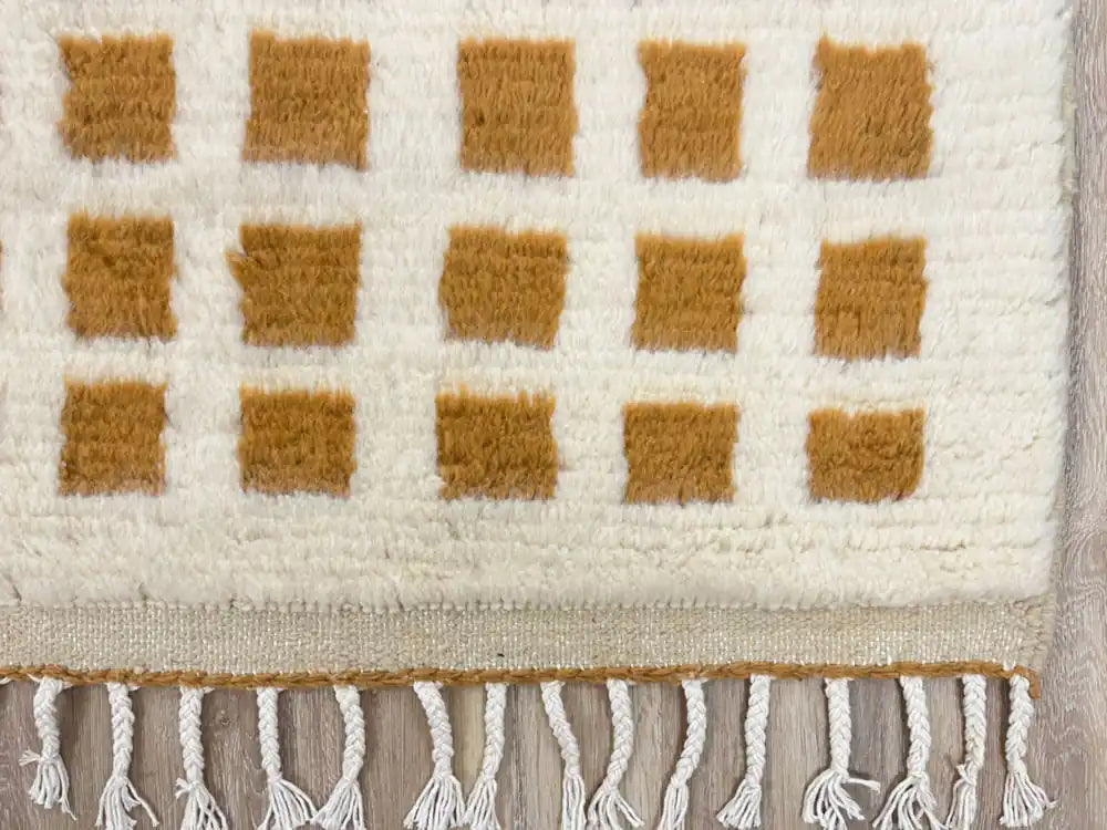 Gros plan sur les franges d’un tapis Beni Ouarain authentique en laine naturelle tissé à la main dans le Haut Atlas marocain.