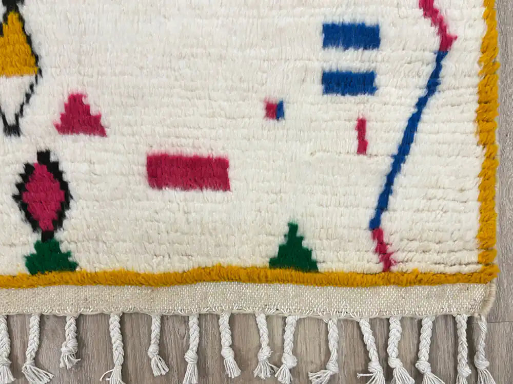 Franges torsadées blanches d’un tapis azilal en laine naturelle