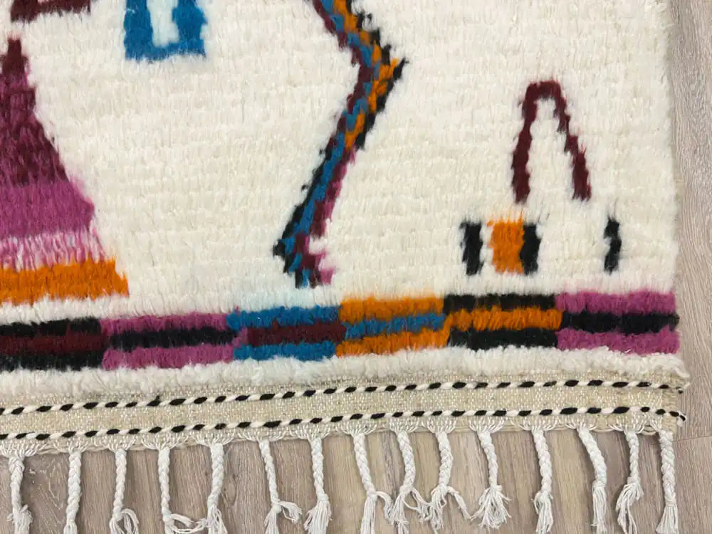 Détail des franges d’un tapis berbère moderne, finition artisanale marocaine en laine naturelle.