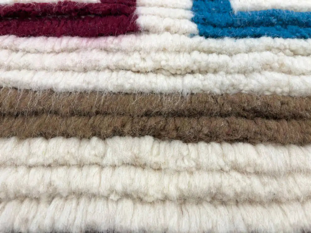 Texture de laine naturelle d’un tapis berbère Azilal unique, fait main par des artisanes marocaines