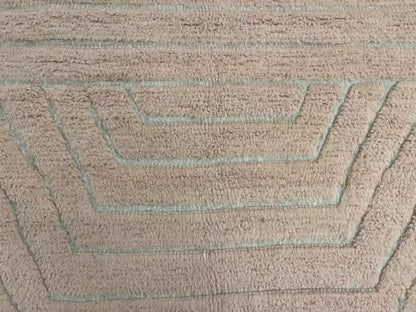 Gros plan sur les lignes géométriques tissées d’un tapis Beni Ouarain en laine naturelle
