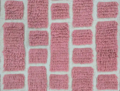 Motifs roses géométriques sur un tapis berbère en laine tissé main