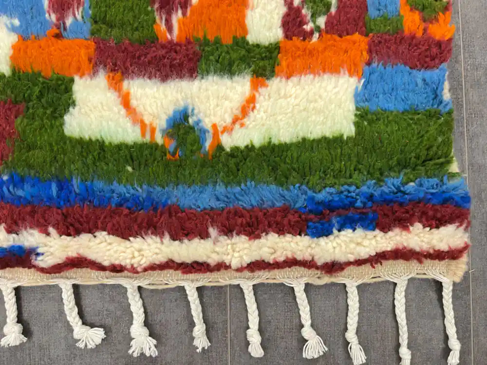 Bordure du tapis boujaad coloré avec franges blanches nouées à la main, finitions artisanales berbères