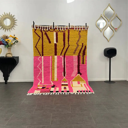 Tapis Azilal rose aux motifs berbères décorant un salon bohème moderne, touche ethnique marocaine