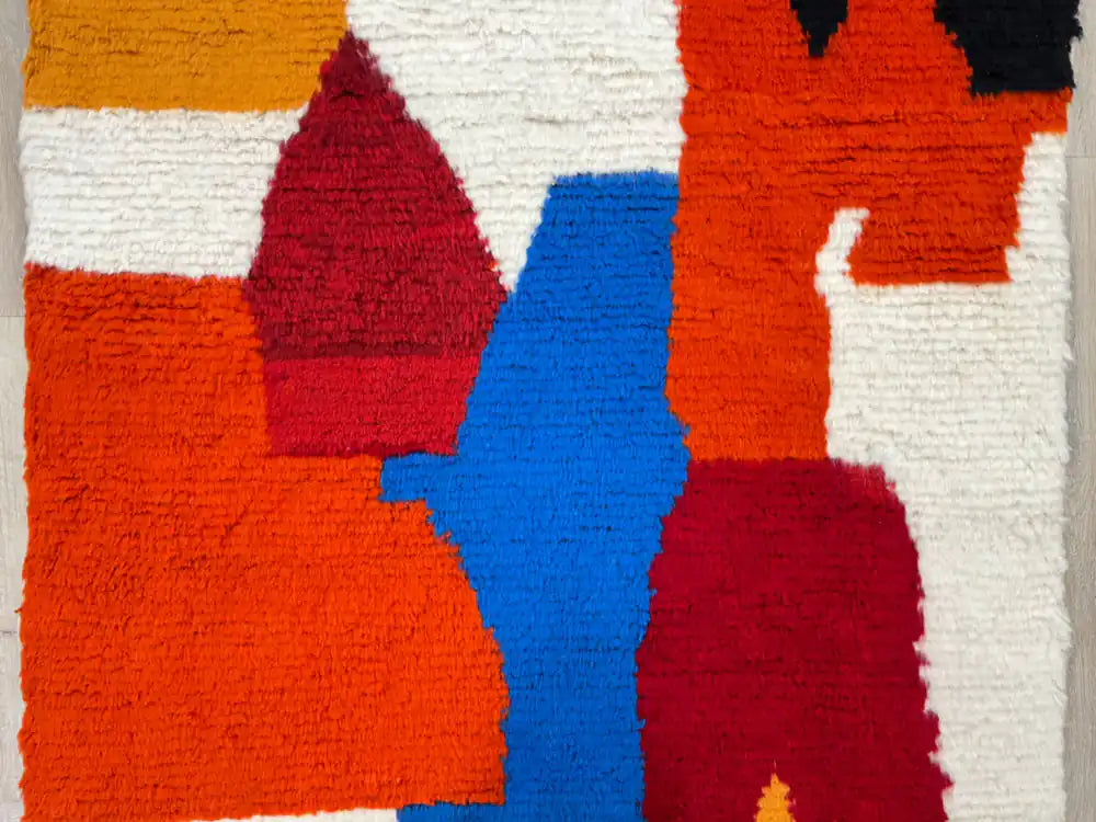 Détail motif bleu rouge noir sur tapis berbère Azilal en laine naturelle, fait main Maroc