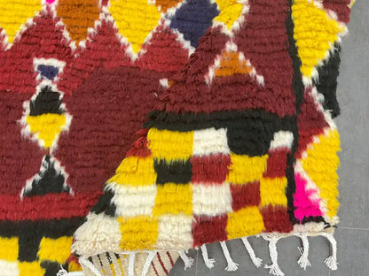 Tapis marocain moderne plié dévoilant son épaisseur et ses nuances dynamiques, fait main