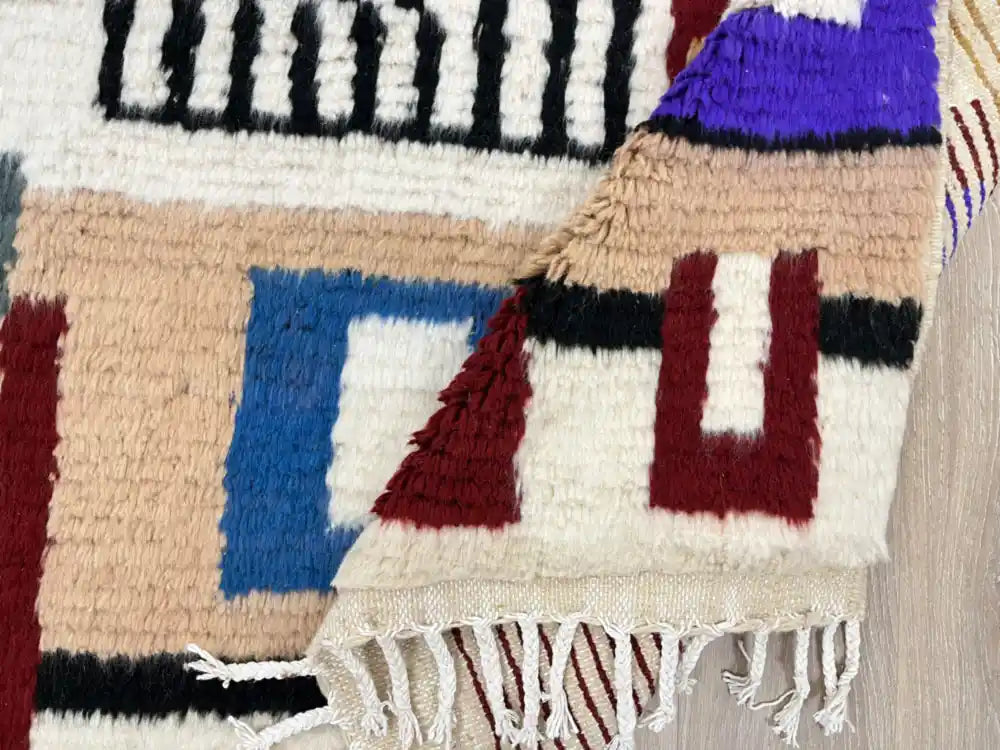 Tapis Azilal plié montrant la densité de la laine et les franges artisanales