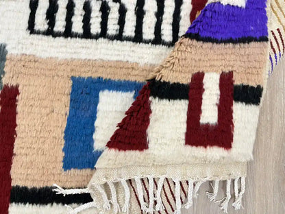 Tapis Azilal plié montrant la densité de la laine et les franges artisanales