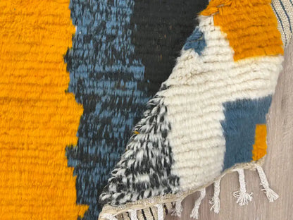 Tapis Azilal plié montrant la texture de la laine et les franges tissées à la main