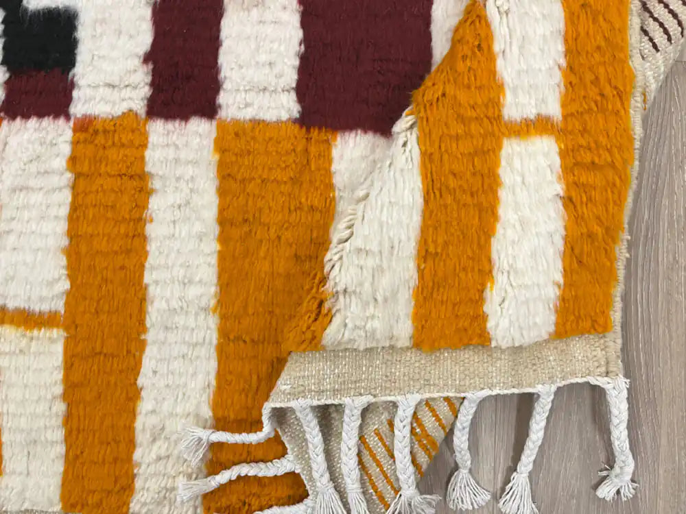 Tapis Azilal plié montrant la laine naturelle et les franges artisanales