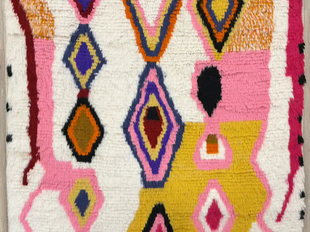 Zoom sur le milieu du tapis Azilal, mettant en valeur les motifs géométriques colorés et symboliques uniques.