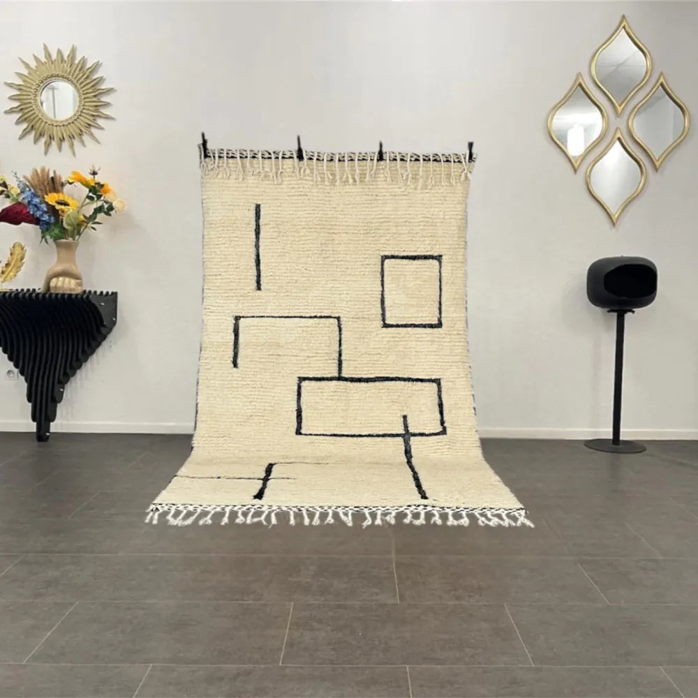 Tapis Beni Ouarain blanc et noir exposé dans un salon moderne, décoration marocaine