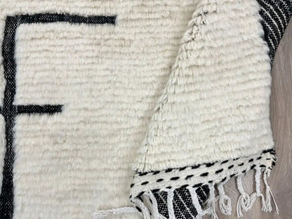 Détail du motif géométrique noir sur fond blanc d’un tapis Beni Ouarain marocain