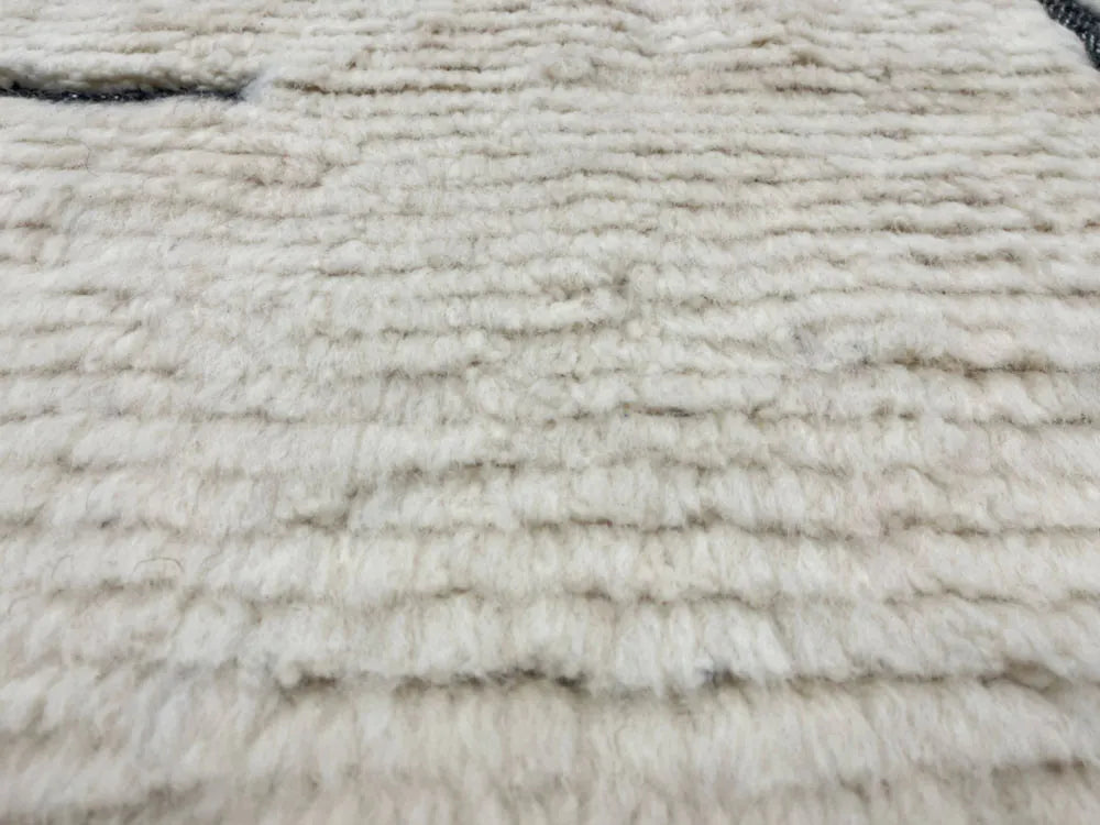 Texture douce et épaisse d’un tapis Beni Ouarain blanc et noir, laine naturelle du Maroc