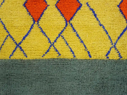 Détail du grand tapis Beni Ouarain, laine épaisse, losanges berbères rouges et lignes bleues sur jaune