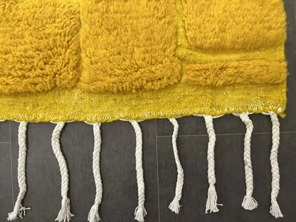Franges nouées d’un tapis Beni Ouarain jaune moutarde en laine naturelle, artisanat marocain