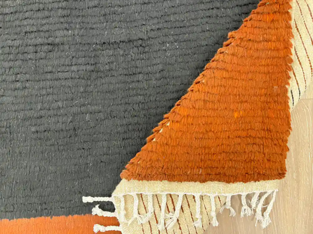 Tapis Beni Ouarain plié, mettant en avant la frange et la qualité de la laine naturelle.