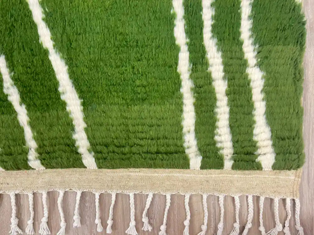 Franges nouées d’un tapis Beni Ouarain vert en laine naturelle, finition artisanale marocaine