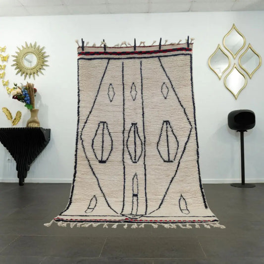 Tapis berbere Beni Ouarain en laine blanche avec motifs noirs, design berbère traditionnel.